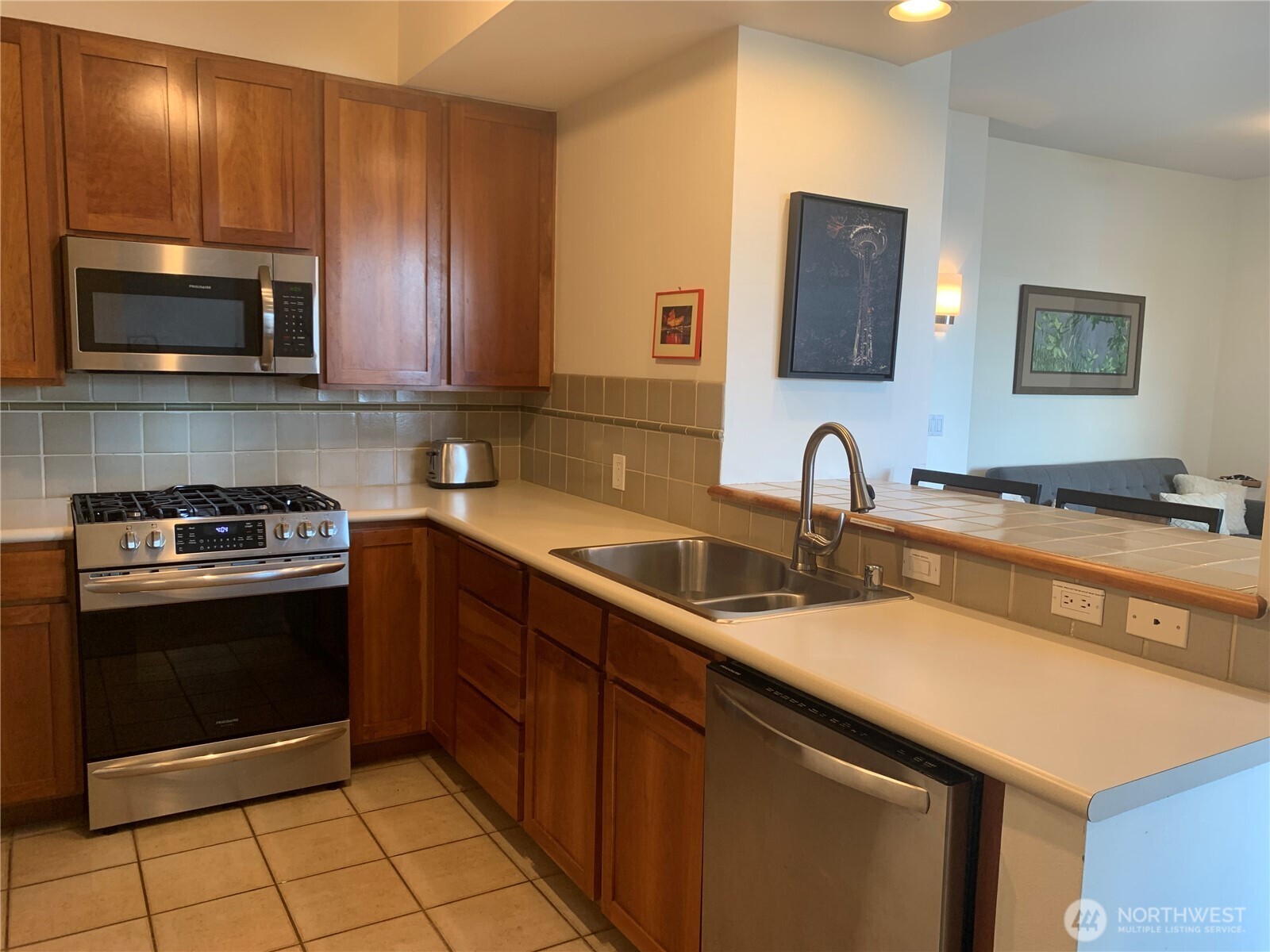 2000 Alaskan Way, Unit 342 Seattle, WA 98121 - Photo 14 of 40 a kitchen with stainless steel appliances a sink stove and microwave