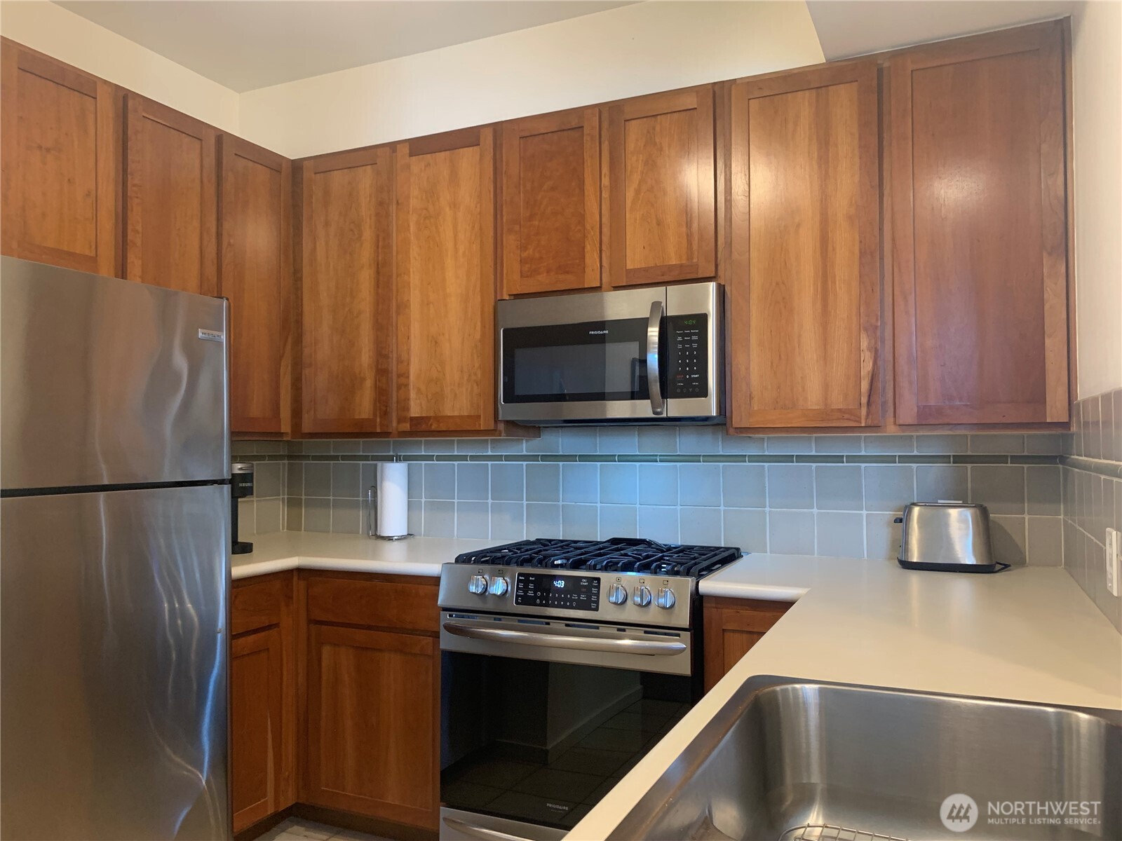 2000 Alaskan Way, Unit 342 Seattle, WA 98121 - Photo 15 of 40 a kitchen with a refrigerator and a sink