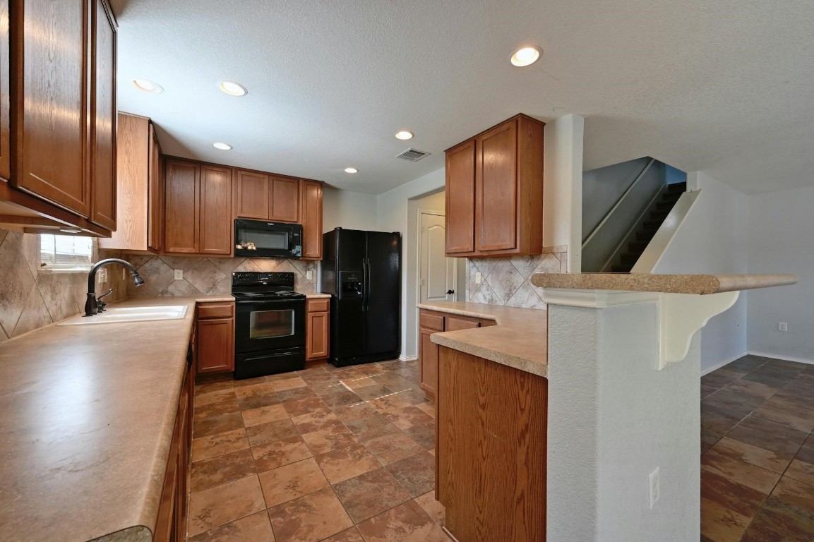 8901 Cornish Hen Cove Austin, TX 78747 - Photo 8 of 29 a kitchen with stainless steel appliances granite countertop a refrigerator sink and stove