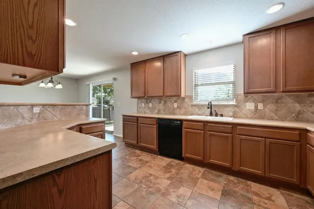 a kitchen with a sink window and cabinets