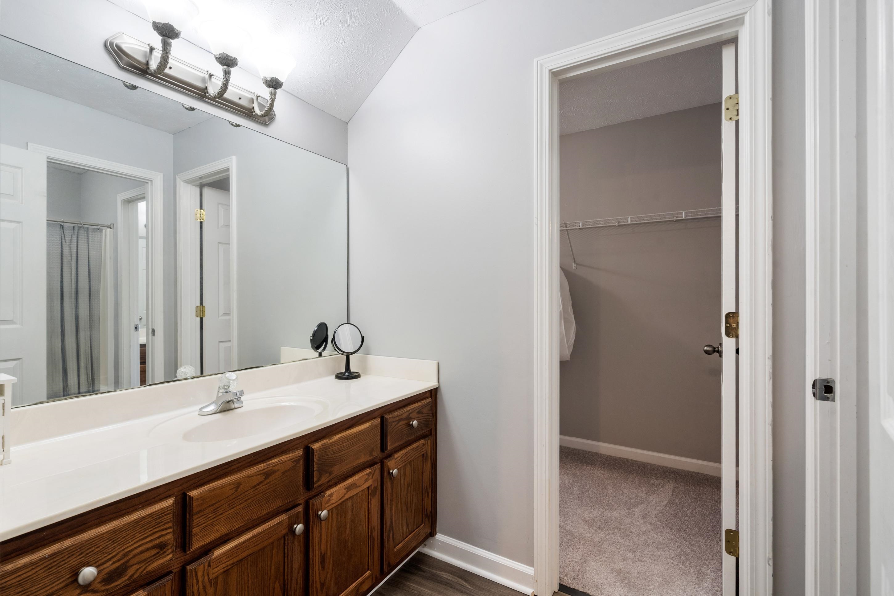 7757 Brunswick Road Millington, TN 38053 - Photo 20 of 40 Full vanity featuring a single basin sink, white countertop, and wood-finish cabinetry