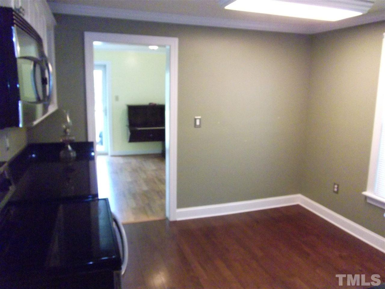 1024 Stallings Road Durham, NC 27703 - Photo 10 of 18 a view of an empty room with wooden floor and a window