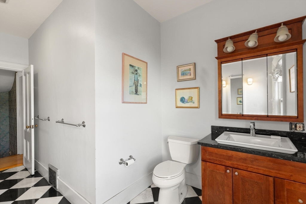 16 Williams Street Salem, MA 01970 - Photo 23 of 29 a bathroom with a granite countertop toilet a sink and a mirror