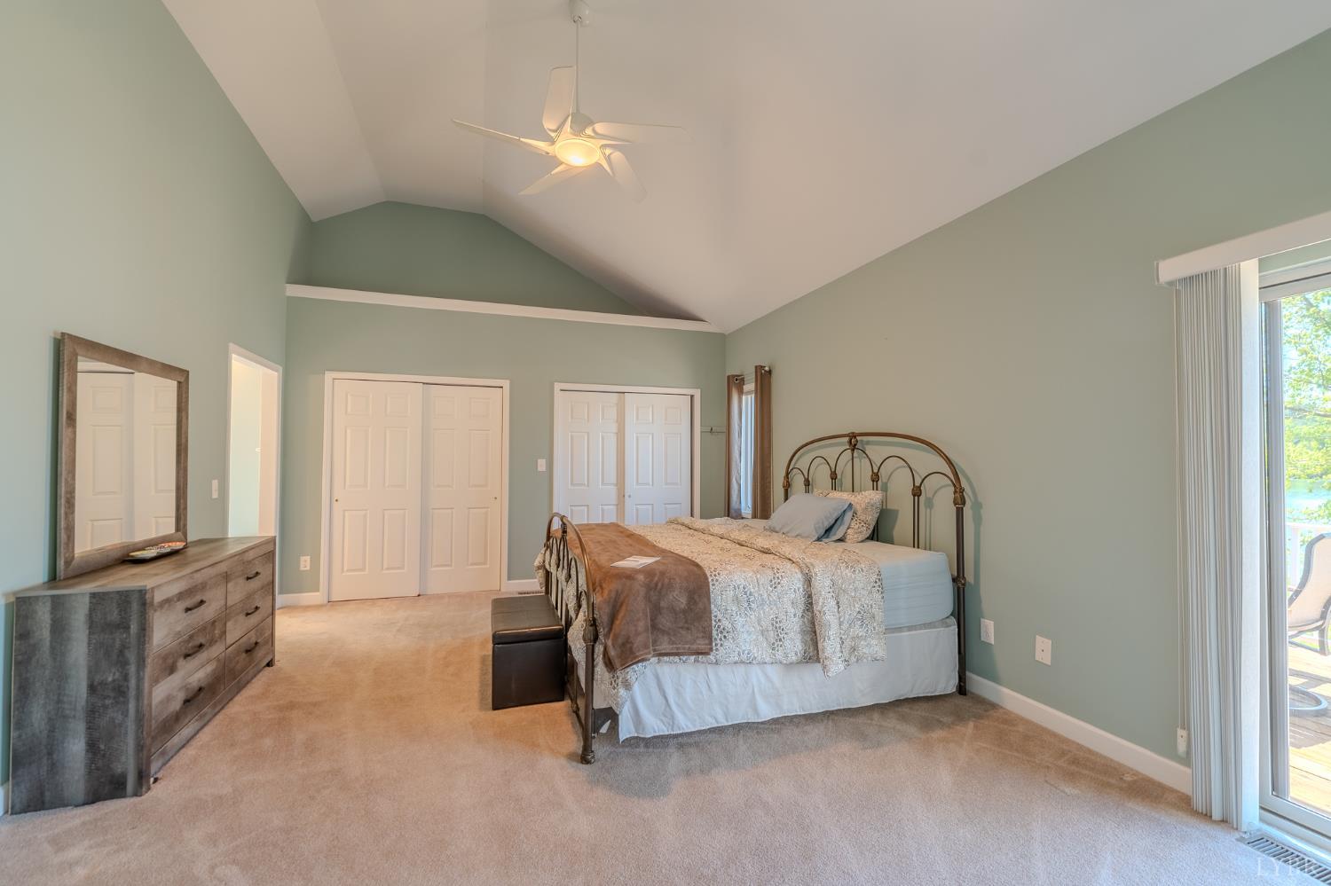 1269 Runaway Bay Road Lynch Station, VA 24571 - Photo 22 of 82 a spacious bedroom with a bed a mirror on dresser and a chandelier