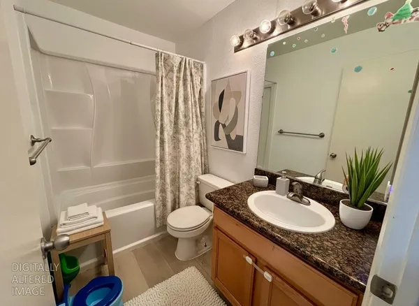 a bathroom with a granite countertop sink toilet a mirror and shower
