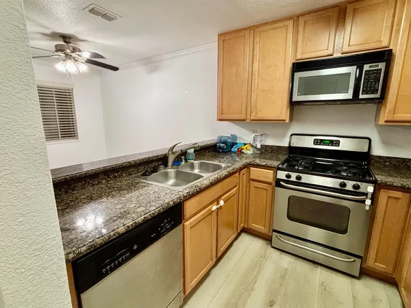 a kitchen with stainless steel appliances granite countertop a sink stove and microwave