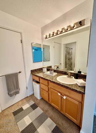 a bathroom with a granite countertop sink and a mirror