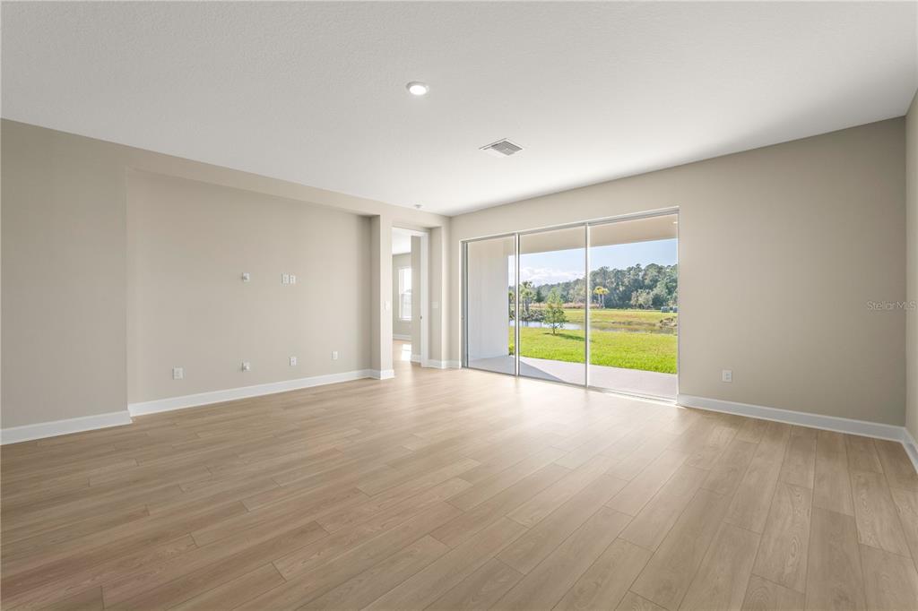 2181 Longliner Loop Wesley Chapel, FL 33543 - Photo 13 of 44 a view of an empty room with wooden floor and a window