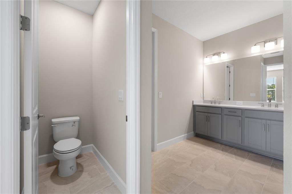 2181 Longliner Loop Wesley Chapel, FL 33543 - Photo 19 of 44 a bathroom with a toilet a sink and mirror