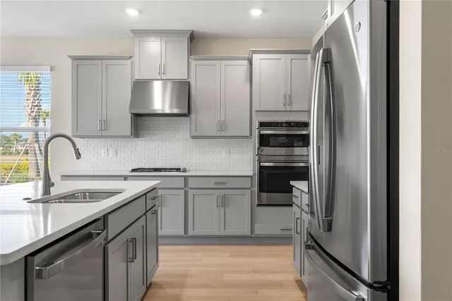 a kitchen with a refrigerator sink and cabinets