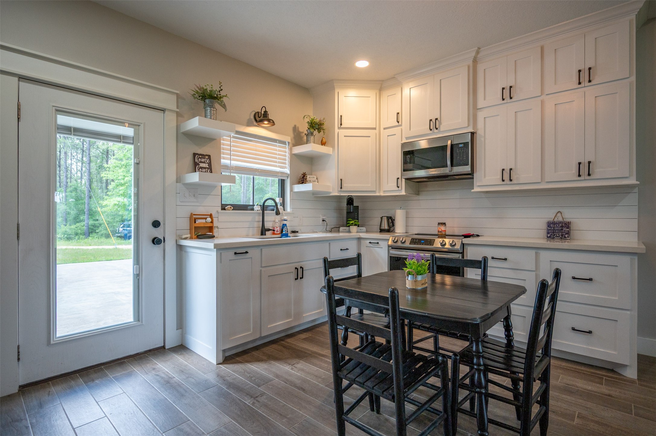 1068 County Road 3200 Colmesneil, TX 75938 - Photo 22 of 43 a kitchen with stainless steel appliances white cabinets and wooden floor