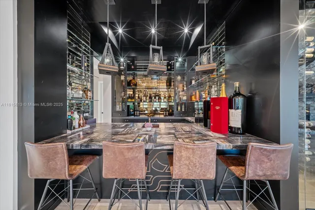 a kitchen with stainless steel appliances granite countertop a dining table chairs and granite counter tops