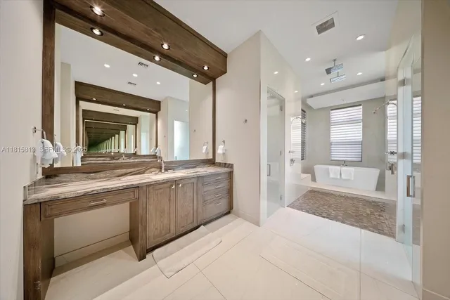 a spacious bathroom with a granite countertop sink mirror and a shower