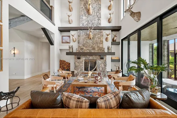 a living room with fireplace furniture and a large window