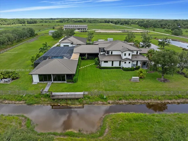 a view of a house with a yard and lake view