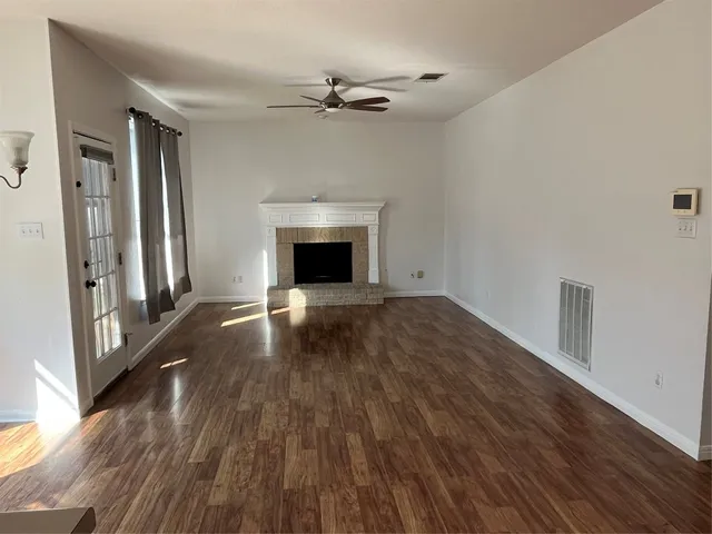 a view of empty room with wooden floor and fireplace