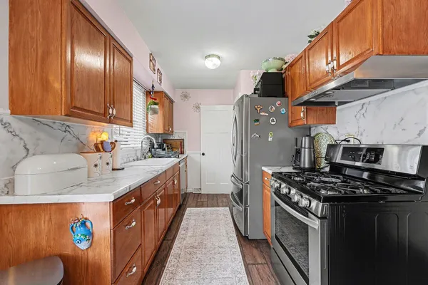 a kitchen with stainless steel appliances granite countertop a stove a sink dishwasher and a refrigerator