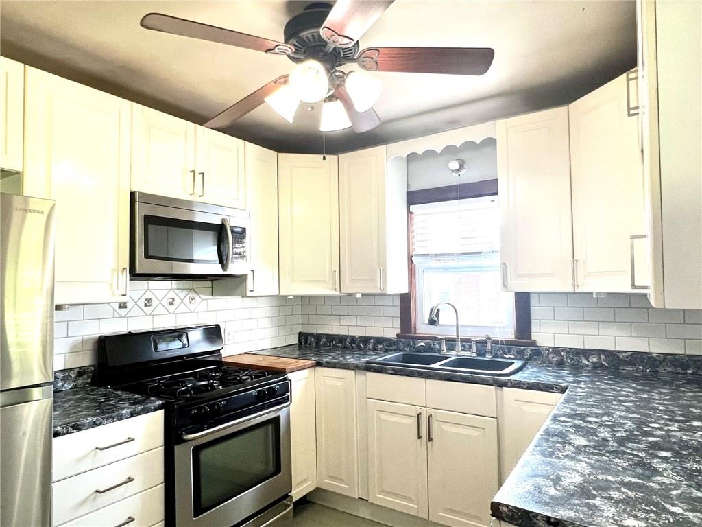 389 Mt Morris Road Mount Morris, PA 15349 - Photo 4 of 25 a kitchen with stainless steel appliances a stove sink microwave and cabinets