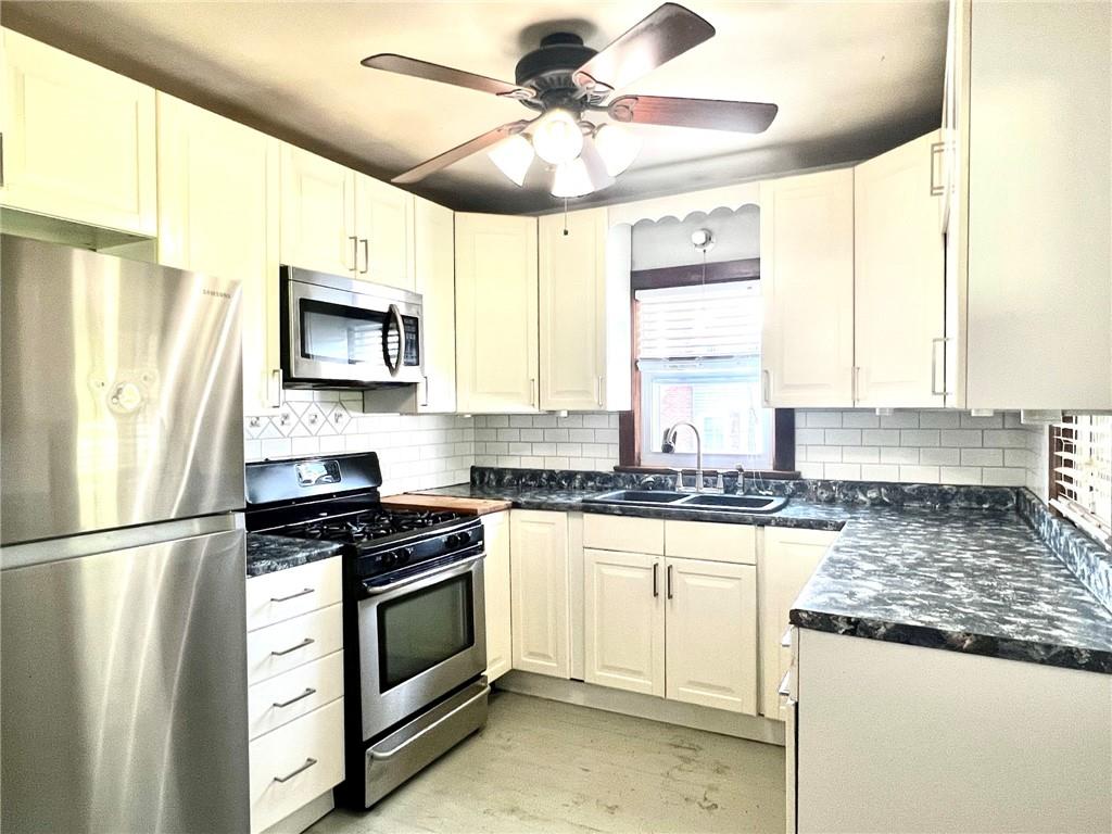 389 Mt Morris Road Mount Morris, PA 15349 - Photo 6 of 25 a kitchen with stainless steel appliances granite countertop a stove a sink and a refrigerator