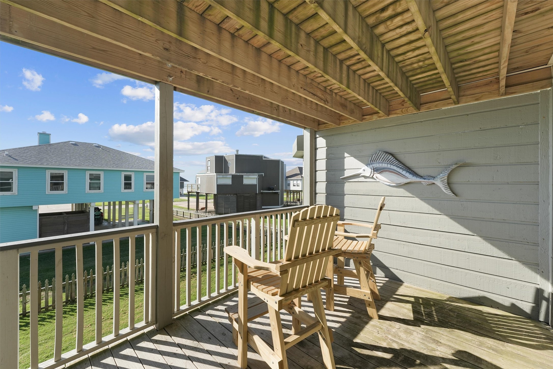 17607 Termini-San Luis Pass Road Galveston, TX 77554 - Photo 24 of 42 This second-floor balcony provides a peaceful spot to enjoy the outdoors, with comfortable high-back chairs for seating. The covered area offers shade, making it perfect for relaxing at any time of day.