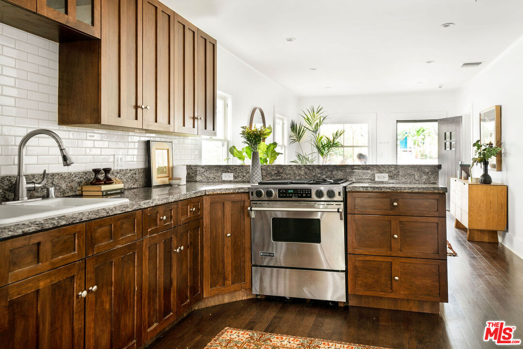 1205 Sanborn Avenue Los Angeles, CA 90029 - Photo 14 of 48 a kitchen with granite countertop wooden cabinets stainless steel appliances and wooden floor