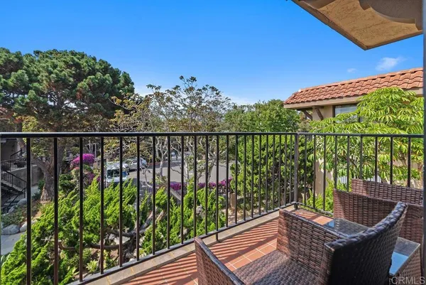 a balcony with wooden floor and outdoor seating