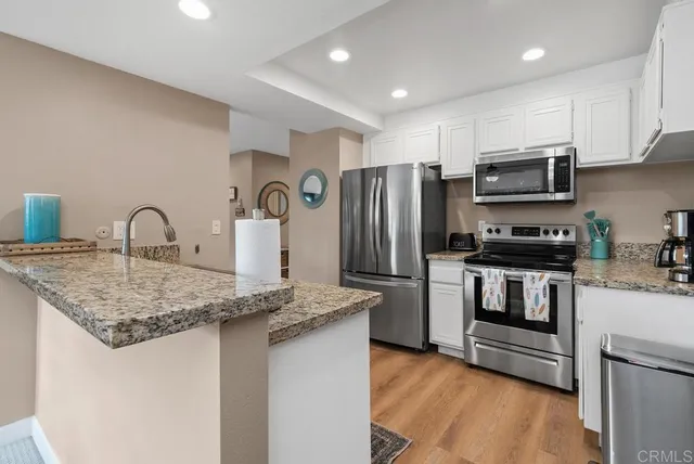 a kitchen with stainless steel appliances granite countertop a refrigerator stove and microwave