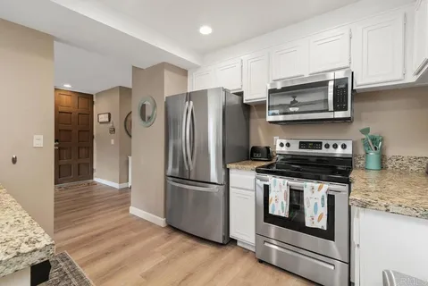 a kitchen with stainless steel appliances granite countertop a sink and a refrigerator