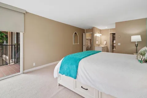 a spacious bedroom with a bed and a lamp