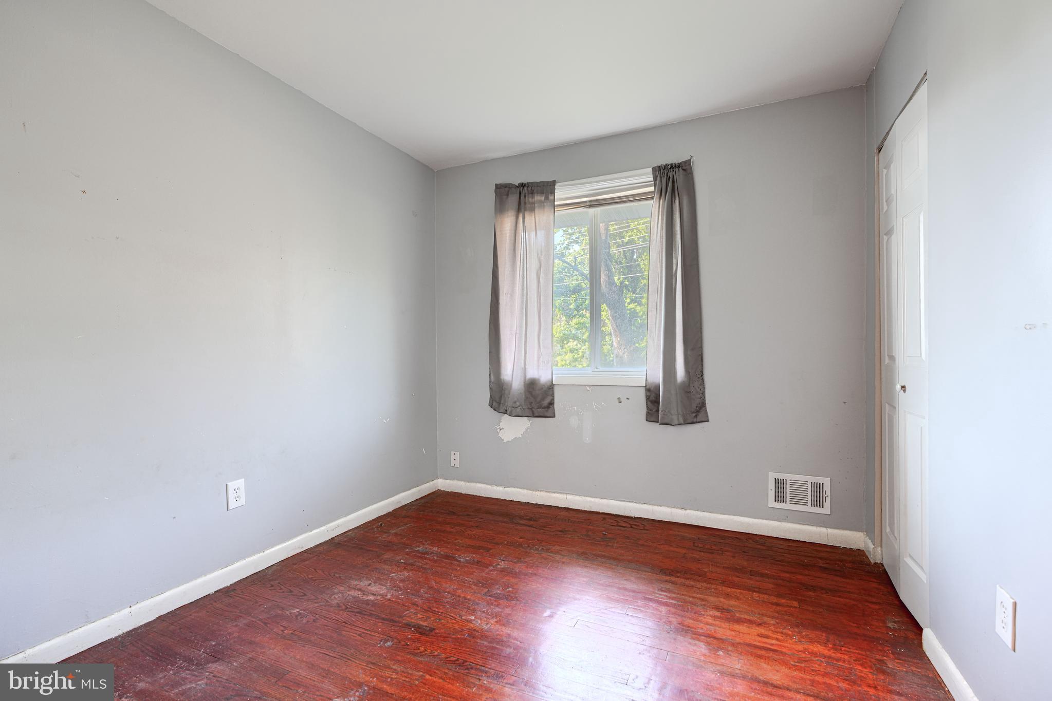9706 Liberty Road Randallstown, MD 21133 - Photo 23 of 43 a view of an empty room with wooden floor and a window