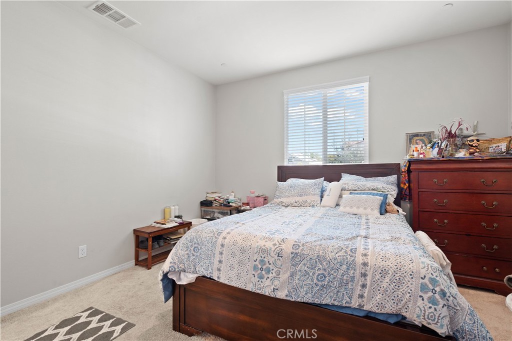 12875 Wainwright Lane Moreno Valley, CA 92555 - Photo 14 of 37 a bedroom with a bed and window