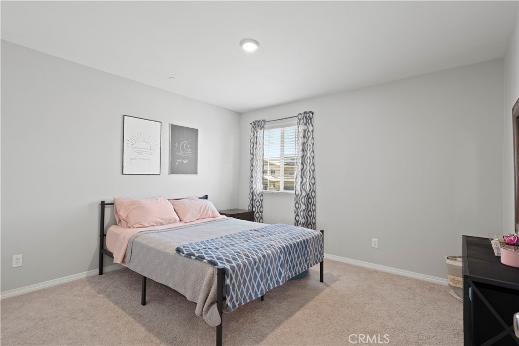 12875 Wainwright Lane Moreno Valley, CA 92555 - Photo 19 of 37 a bedroom with a bed and a window