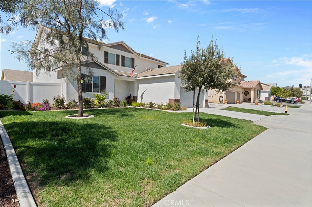 12875 Wainwright Lane Moreno Valley, CA 92555 - Photo 2 of 37 a front view of a house with a yard and trees