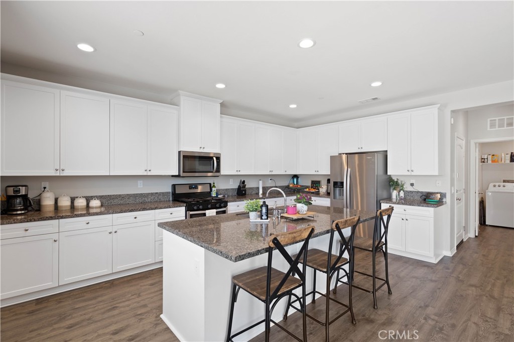 12875 Wainwright Lane Moreno Valley, CA 92555 - Photo 5 of 37 a kitchen with stainless steel appliances a table and chairs in it