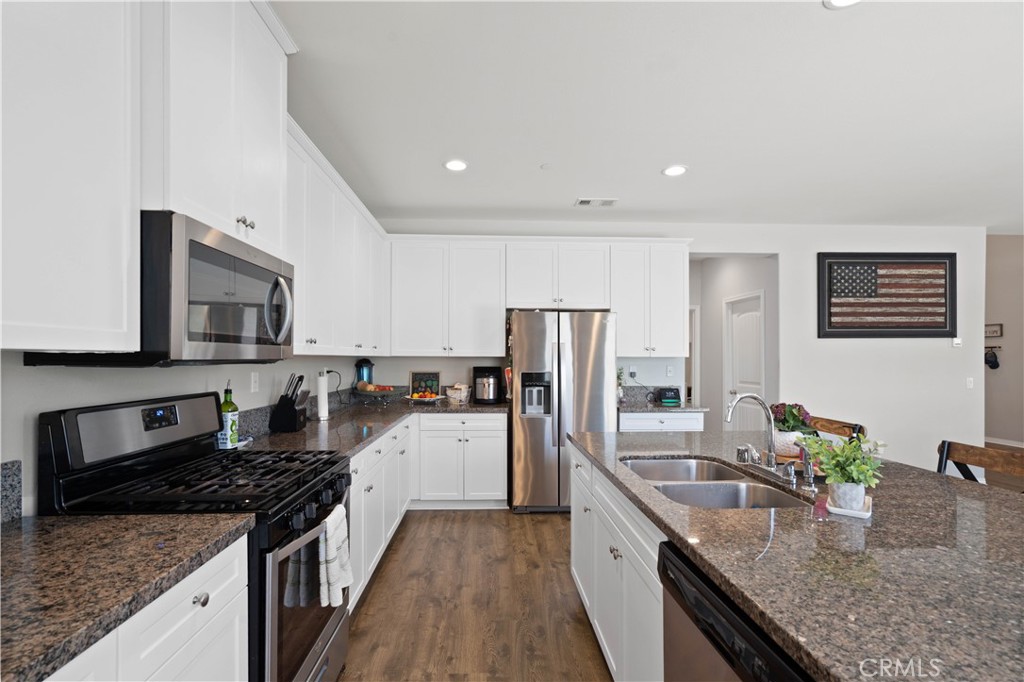 12875 Wainwright Lane Moreno Valley, CA 92555 - Photo 6 of 37 a kitchen with stainless steel appliances granite countertop a sink stove and refrigerator