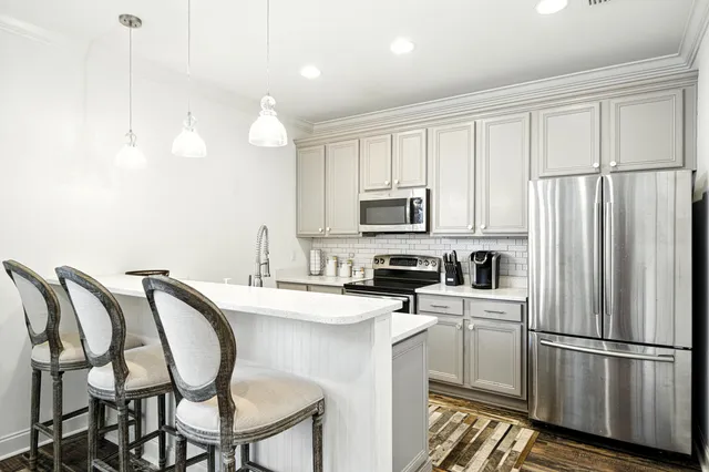 a kitchen with stainless steel appliances a refrigerator sink and microwave