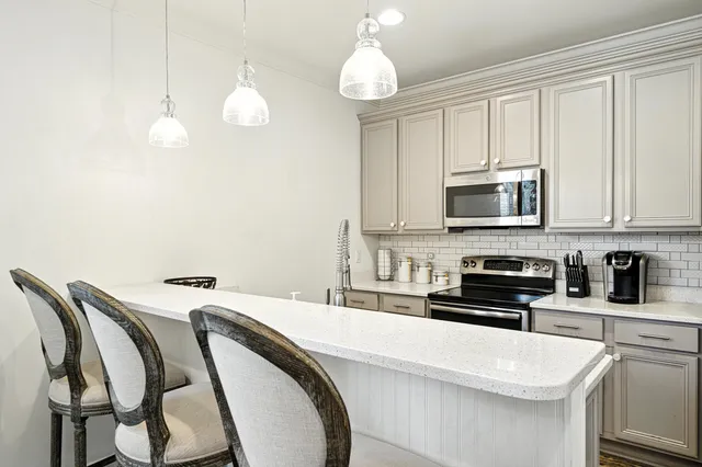 a kitchen with appliances a sink and cabinets