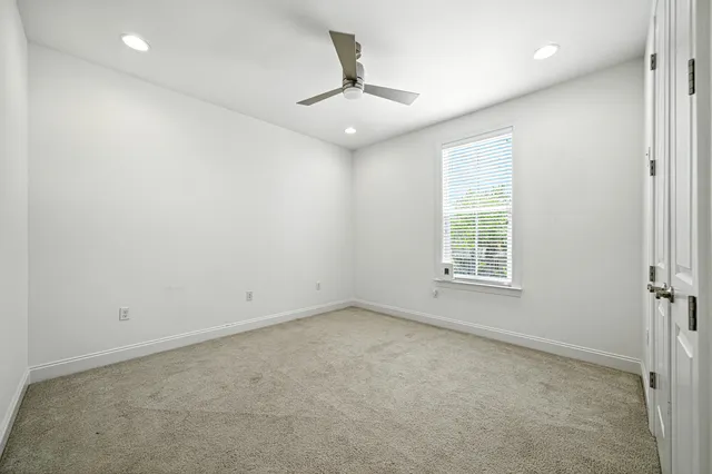 an empty room with a window and a ceiling fan
