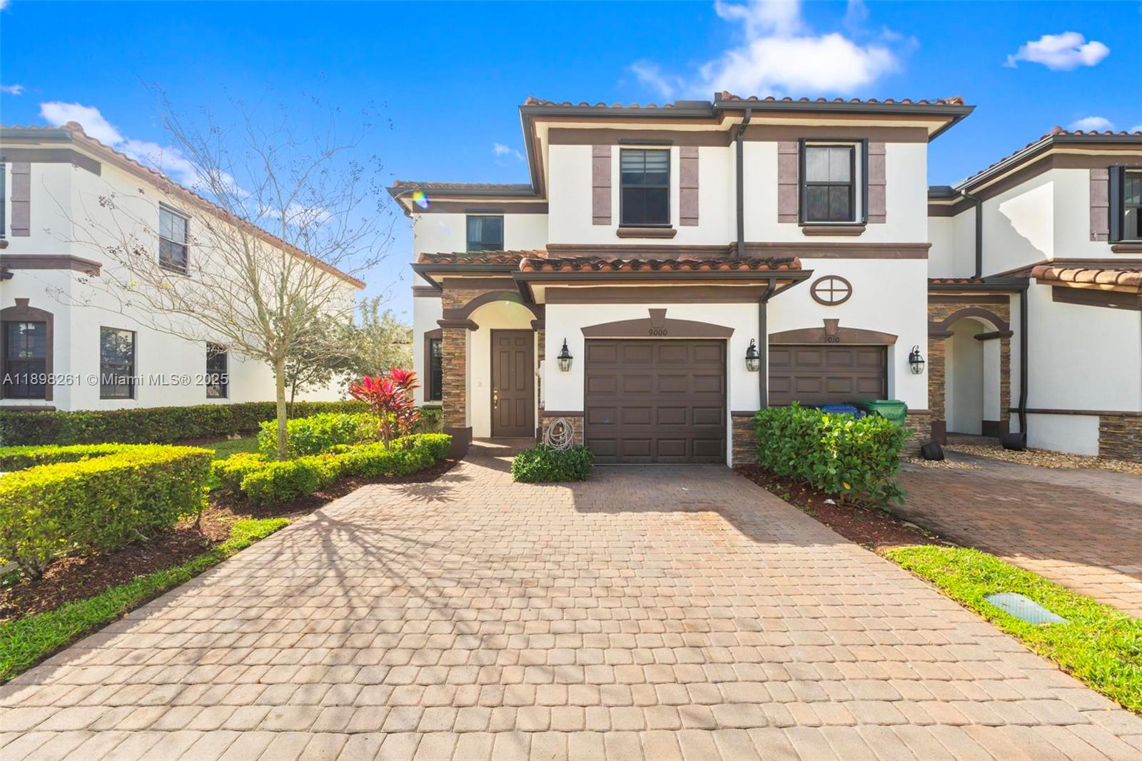 9000 Northwest 183rd Street, Unit 9000 Hialeah, FL 33018 - Photo 1 of 41 a front view of a house with a yard and garage
