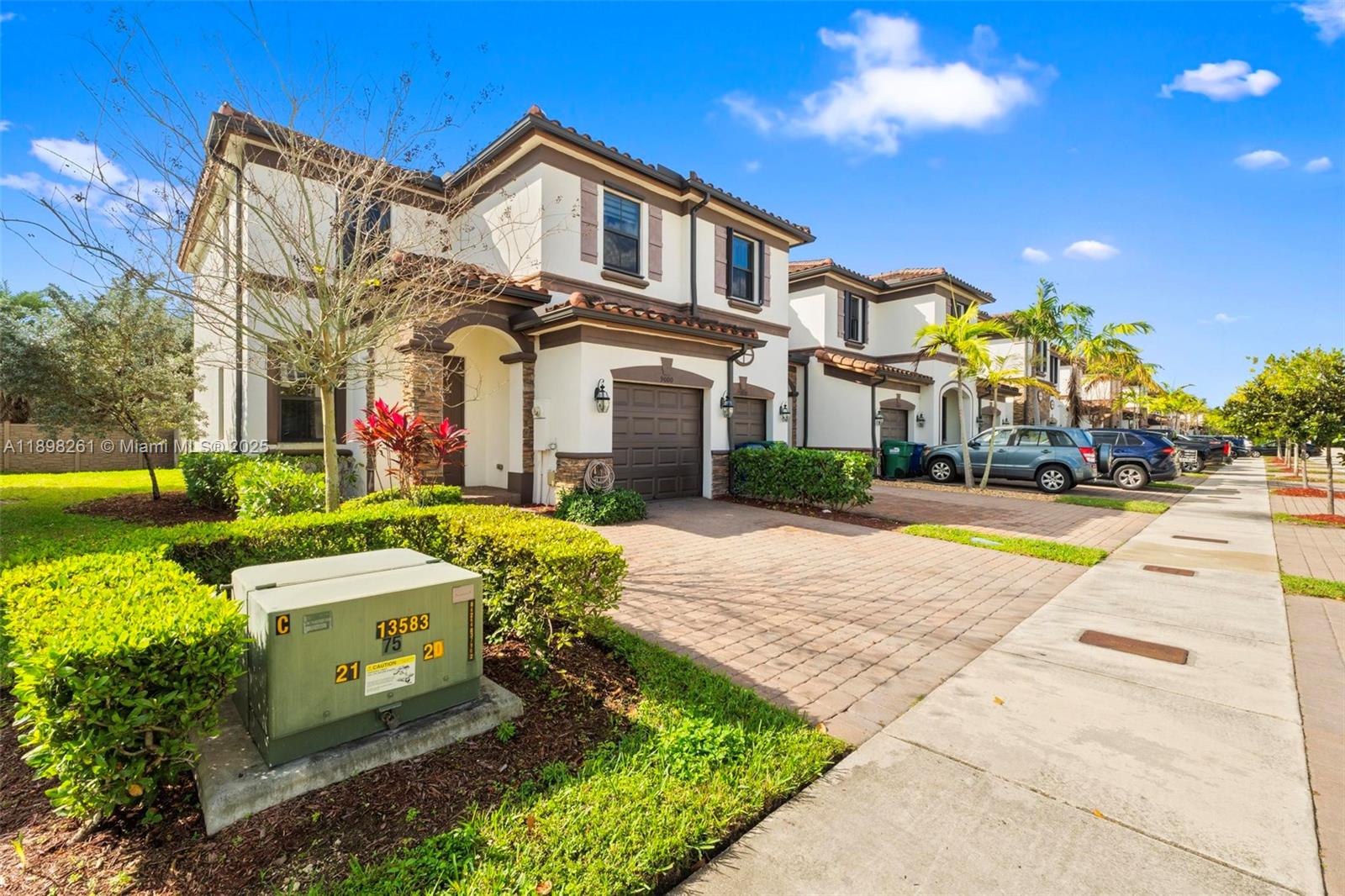 9000 Northwest 183rd Street, Unit 9000 Hialeah, FL 33018 - Photo 2 of 41 a front view of a house with a yard