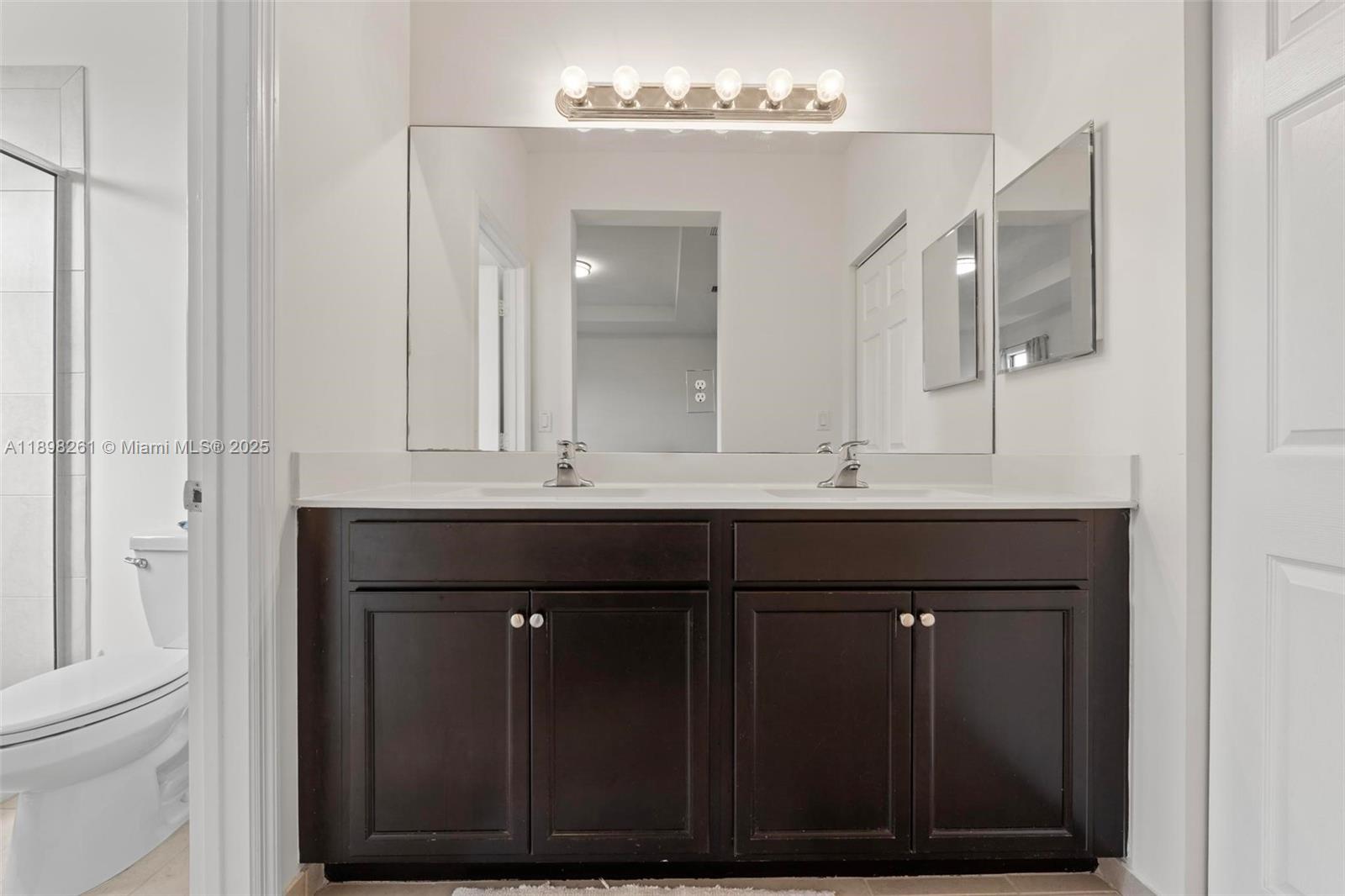 9000 Northwest 183rd Street, Unit 9000 Hialeah, FL 33018 - Photo 30 of 41 a bathroom with a sink vanity and a mirror