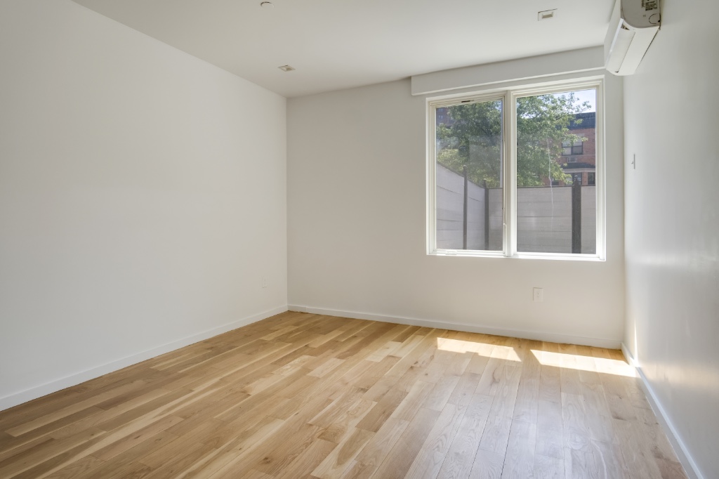 311 Hart Street, Unit 1A Brooklyn, NY 11206 - Photo 7 of 16 a view of empty room with wooden floor and fan