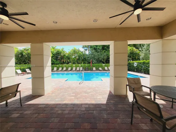 a view of a patio with table and chairs floor to ceiling window and garden