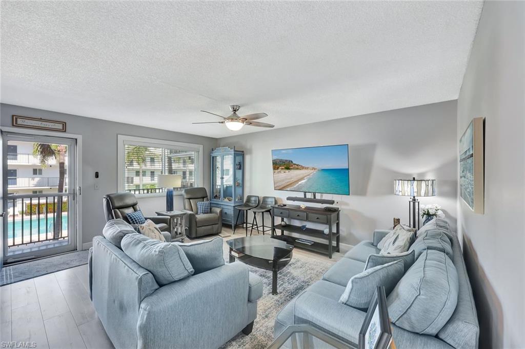 766 Central Avenue, Unit 207 Naples, FL 34102 - Photo 3 of 18 a living room with furniture and a flat screen tv