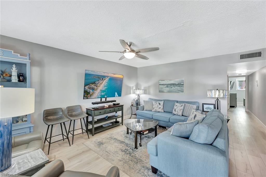 766 Central Avenue, Unit 207 Naples, FL 34102 - Photo 4 of 18 a living room with furniture and a ceiling fan