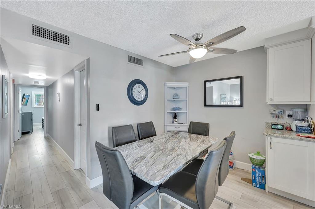 766 Central Avenue, Unit 207 Naples, FL 34102 - Photo 8 of 18 a view of a dining room with furniture and wooden floor