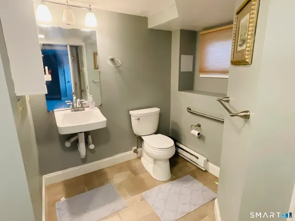 a bathroom with a toilet a sink and mirror