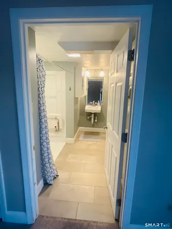 a view of a hallway with wooden floor and a living room