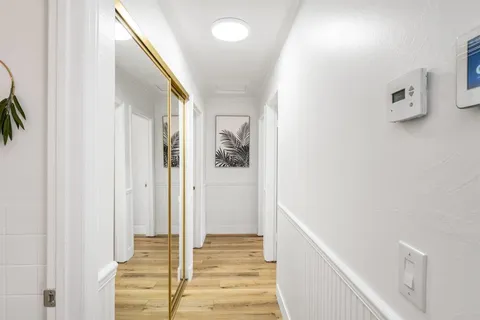 a view of a hallway with wooden floor and staircase