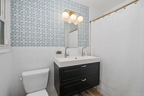 a bathroom with a toilet a sink and mirror